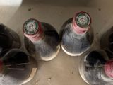 six bottles of wine are lined up in a row on a counter