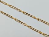 a close up of two gold chains on a white surface