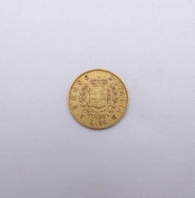 gros plan d'une pièce d'or sur une surface blanche