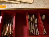 many spoons and spoon spoons in a red drawer