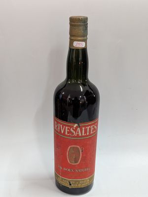 an old bottle of wine sitting on top of a white table