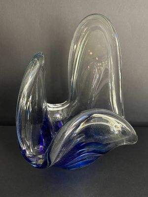 une sculpture en verre bleu et transparent posée sur une table