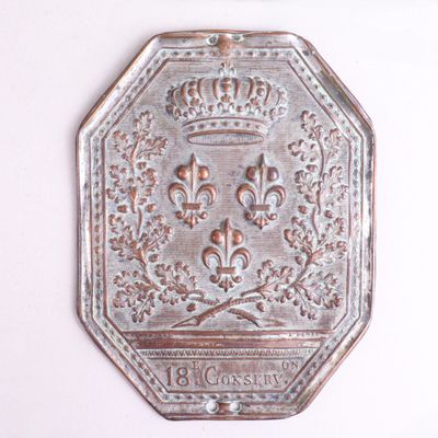 une plaque métallique sur laquelle figure une couronne