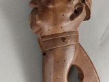 un petit objet en bois sur lequel est représenté un visage