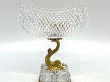 bol en verre doré et transparent posé sur un socle doré, sur fond blanc