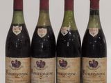 four bottles of wine are lined up in a row on a white surface