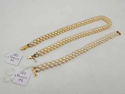 a pair of pearl necklaces with tags on them