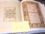 un livre ouvert avec une écriture dessus, posé sur une table
