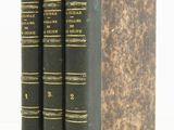 three books sitting on top of each other on a white surface