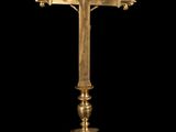an image of a gold cross on a pedestal with a black background