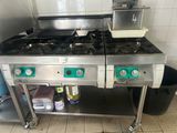 deux cuisinières dans une cuisine, avec une poubelle en arrière-plan