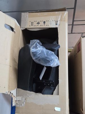 une valise noire dans un carton posé par terre