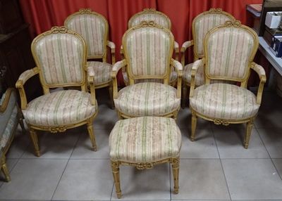 six chaises et un pouf dans une pièce