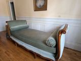 une chaise longue au milieu d'une pièce, avec un tableau accroché au mur