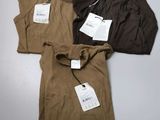 trois t-shirts pour homme, encore étiquetés, posés sur une table