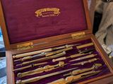a person holding a wooden box with a bunch of knives in it