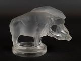 une figurine en verre transparent représentant un taureau posée sur un socle noir