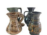 two vases sitting next to each other on a white surface
