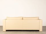 an image of a white leather couch sitting on top of a cement floor