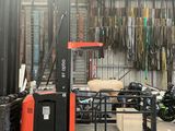 a forklift in a warehouse with a lot of stuff on the floor
