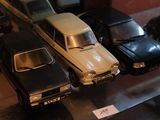 Plusieurs petites voitures sont exposées dans une vitrine.