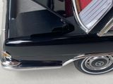 a close up of a black car with a red tie on it