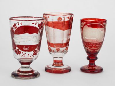 three wine glasses sitting next to each other on a table