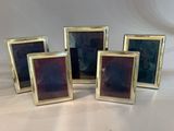 a set of four gold picture frames with purple glass in them
