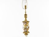 a gold lamp with a glass shade on top of it