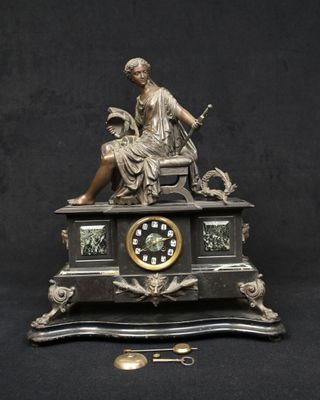 une statue de femme assise au sommet d'une horloge