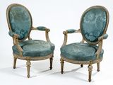 paire de fauteuils rembourrés bleus aux pieds en bois sculpté