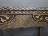 a black and gold table with a bird design on it