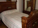 un lit avec une tête de lit en bois et un miroir accroché au mur
