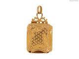 gros plan d'un pendentif en or sur fond blanc