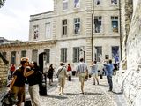 de nombreuses personnes marchant dans une rue pavée en ville