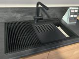 a black sink with a black faucet on the counter