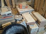 un tas de bois au milieu d'une pièce, avec un seau posé par terre
