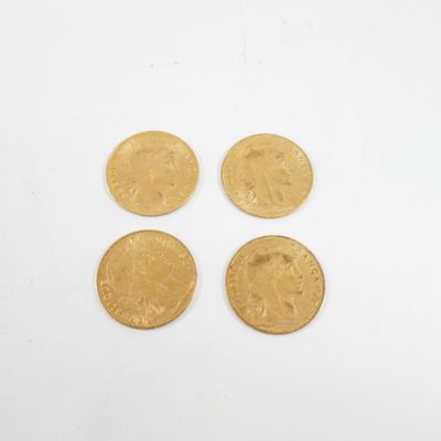 un gros plan sur quatre pièces d'or posées sur une surface blanche