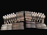 many forks and spoons arranged together on a black background