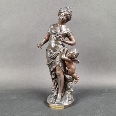 bronze statue of a woman holding a child on her lap