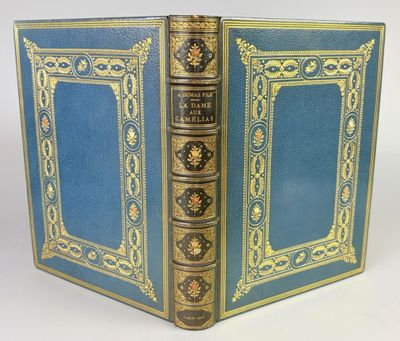 un vieux livre bleu avec des bordures dorées et une bordure dorée