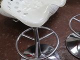 deux tabourets blancs placés l'un à côté de l'autre sur une table