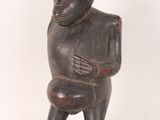statue of a monkey holding a piece of wood in its right hand
