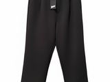 un pantalon noir suspendu à un cintre sur fond blanc