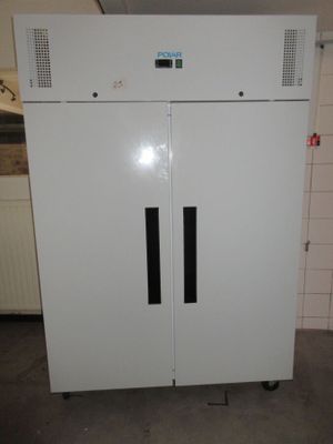 un réfrigérateur blanc avec une porte noire dans une pièce