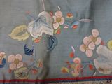 a close up of a blue and red table cloth with flowers on it