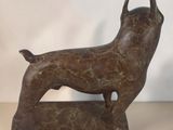 bronze statue of a dog on a base on a table