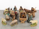 many figurines of people and animals that are on the floor