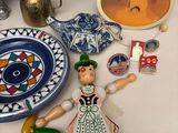 a table with a doll, a plate, a bowl, and other items on it