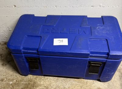 une boîte à outils bleue posée par terre devant un mur